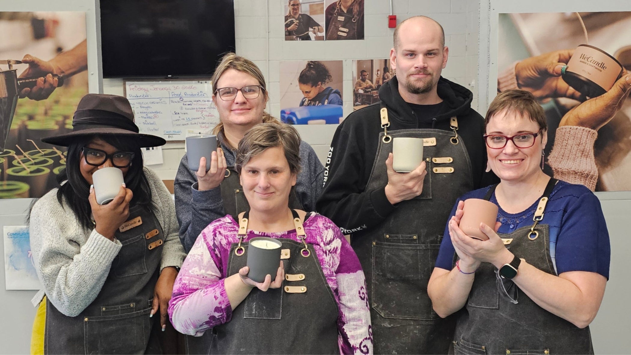 WeCandle artisans holding their handmade candles in the studio